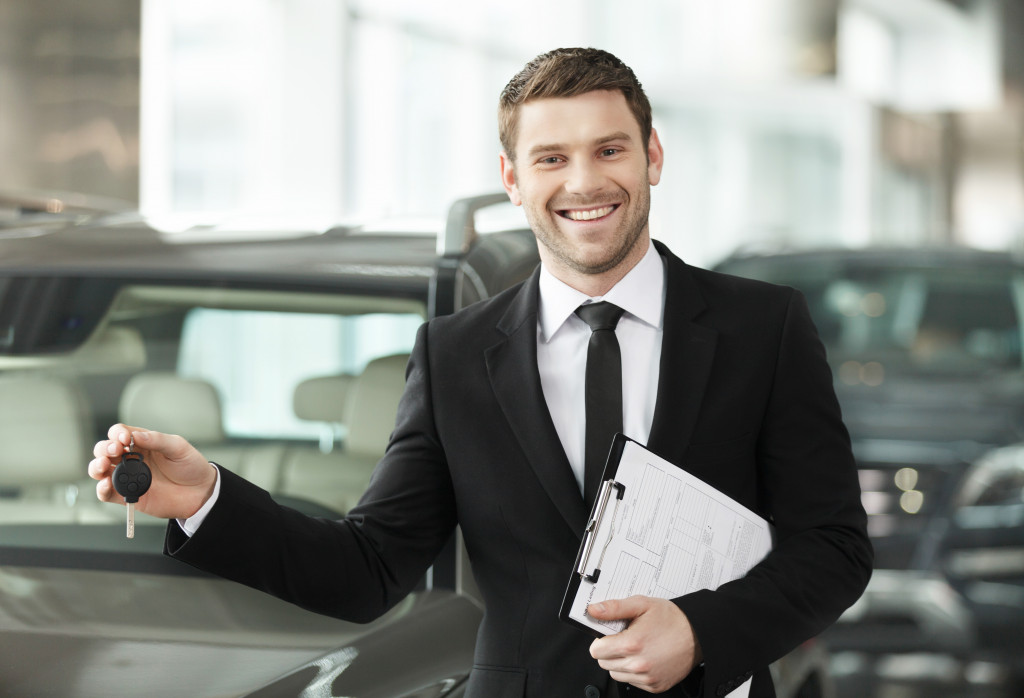 sales agent holding a key of a car