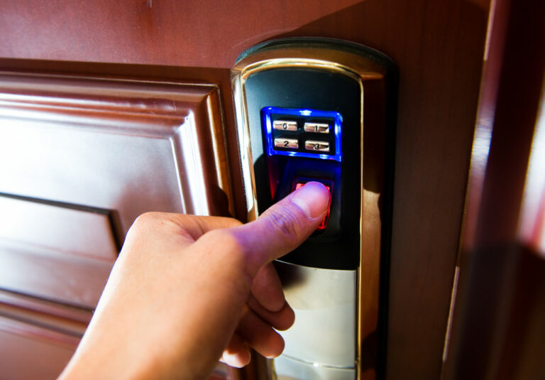 Hand opening a door using a biometrics scanner.